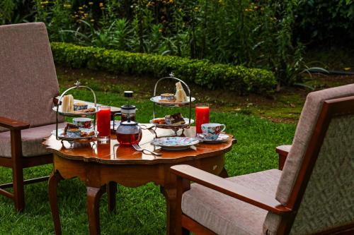a table with plates of food on top of it at Lockhart Bungalow Munnar - A CGH Earth SAHA Experience in Munnar