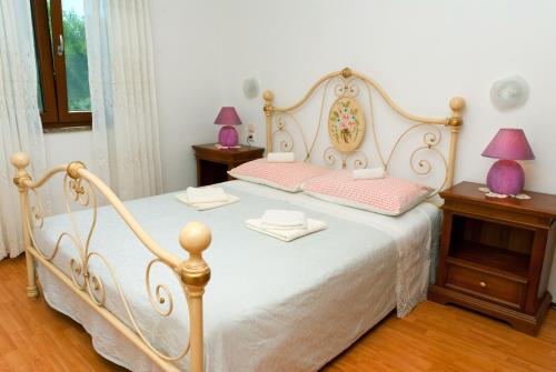 1 dormitorio con 1 cama blanca y 2 mesitas de noche en House Soni, en Rovinj