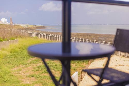 a table in front of a window with a view of the beach at Penghu Swing Sea Homestay in Magong