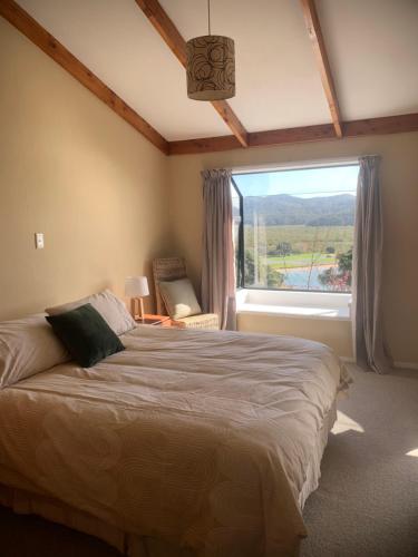 a bedroom with a bed and a large window at The Retreat in Paihia