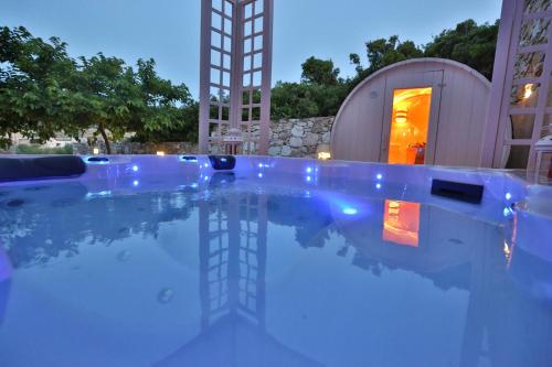 una piscina por la noche con una torre en el fondo en Ventoura Studios & Apartments, en Galissas