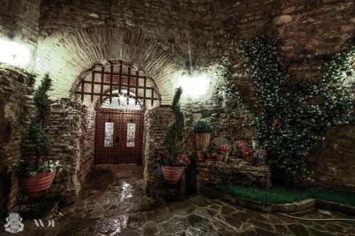 a stone hallway with potted plants in a building at Hotel Guri in Elbasan