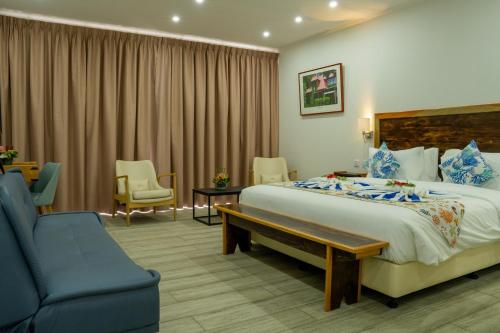 um quarto de hotel com uma cama e uma cadeira azul em Lakaz Kreol em Beau Vallon