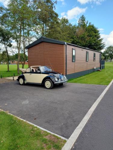 a car parked in a parking lot next to a building at JJs Lodge Oaktree in Thornton