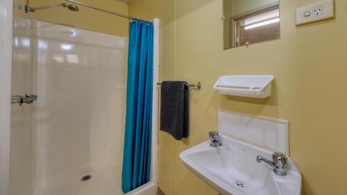 une salle de bain avec lavabo et douche dans l'établissement White Cliffs Hotel, à White Cliffs