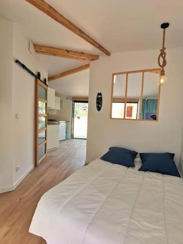 une chambre avec un grand lit blanc avec des oreillers bleus dans l'établissement Appartement sur les hauteurs de la ciotat, à Ceyreste