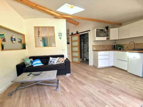 un salon avec un canapé et une cuisine dans l'établissement Appartement sur les hauteurs de la ciotat, à Ceyreste