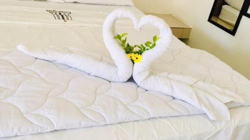 Dos cisnes hechos de toallas en una cama en Hotel Grecia Costa Rica, en Grecia