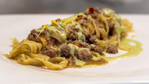 a plate of pasta with meat and sauce at Casa Grimaldi Hotel & Restaurant tre stelle S in Matelica