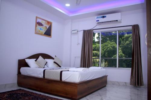 Un dormitorio con una cama grande y una ventana en ELL Parasio, en Port Blair