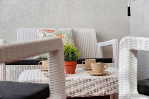 a table and chairs with cups and a plant on it at Torviscas Endless Summer in Adeje
