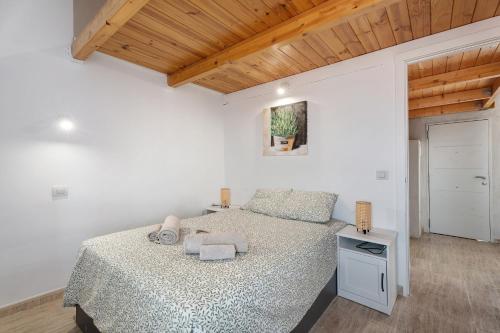 a white bedroom with a bed and a wooden ceiling at Torviscas Endless Summer in Adeje