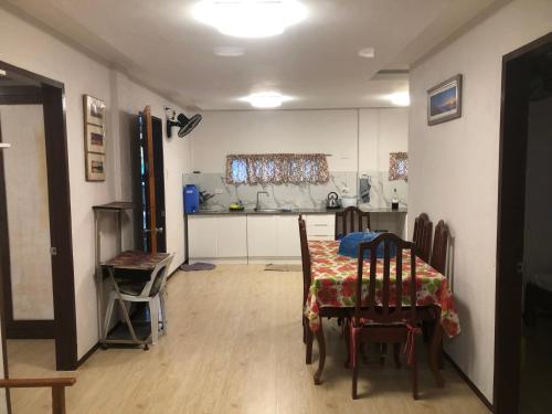 a dining room with a table and a kitchen at Villas de piscina in Sipalay