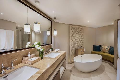 a bathroom with two sinks and a large tub at Royal Palm Beachcomber Luxury in Grand Baie