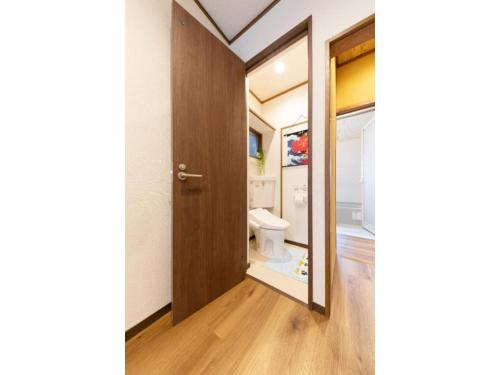 een badkamer met een toilet en een houten deur bij Shirakabanoyado Shimizu - Vacation STAY 12447 in Osaka