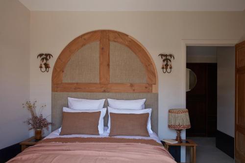 a bedroom with a large bed with a wooden headboard at Maisons 322 - Maison La Lumineuse in Le Bois-Plage-en-Ré