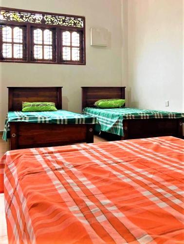 a room with two beds in a room at Moderncore Hostel in Anuradhapura