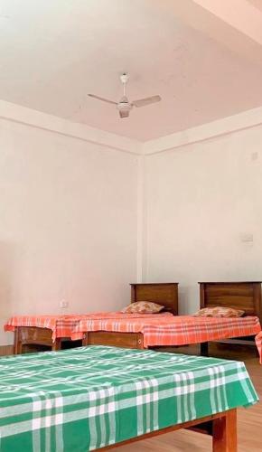 a room with two beds and a ceiling at Moderncore Hostel in Anuradhapura