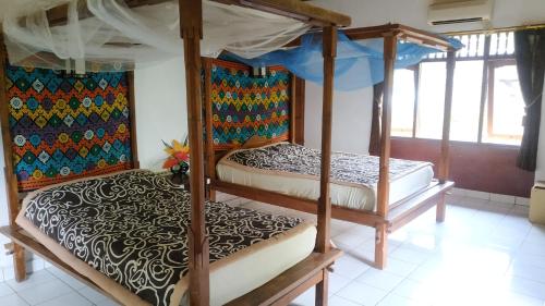 two bunk beds in a room with windows at Pondok Wisata Grya Sari in Banjar
