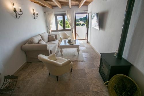 a living room with couches and chairs and a table at AIRE RURAL JIMENA in Jimena de la Frontera