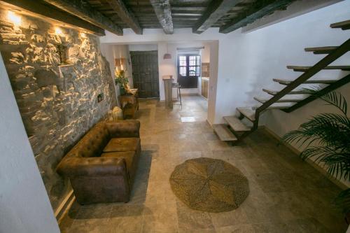 a living room with a couch and a stone wall at AIRE RURAL JIMENA in Jimena de la Frontera