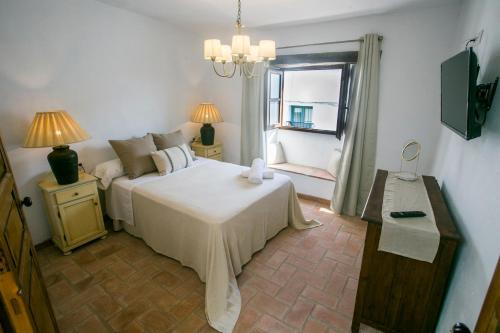 a bedroom with a large bed and a window at AIRE RURAL JIMENA in Jimena de la Frontera