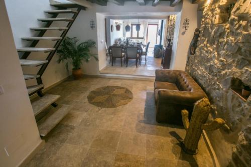 a living room with a couch and a stone wall at AIRE RURAL JIMENA in Jimena de la Frontera