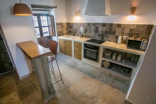 a kitchen with a counter and a table in it at AIRE RURAL JIMENA in Jimena de la Frontera