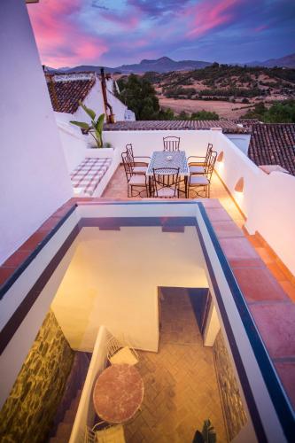 a pool on the roof of a house with a table and chairs at AIRE RURAL JIMENA in Jimena de la Frontera