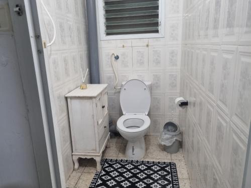 bagno bianco con servizi igienici e finestra di בית אירוח בנהריה a Nahariyya