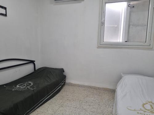 una camera da letto con un letto e uno specchio a parete di בית אירוח בנהריה a Nahariyya