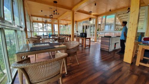 a person standing in a room with tables and chairs at The Woods Retreat in Lansdowne