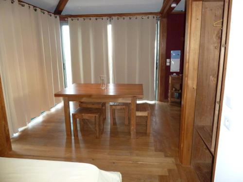 a dining room with a wooden table and chairs at bambous-bungalows in LʼEntre-Deux