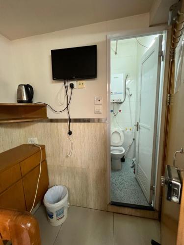 a bathroom with a toilet and a tv on the wall at 泰豪賓館 in Hong Kong
