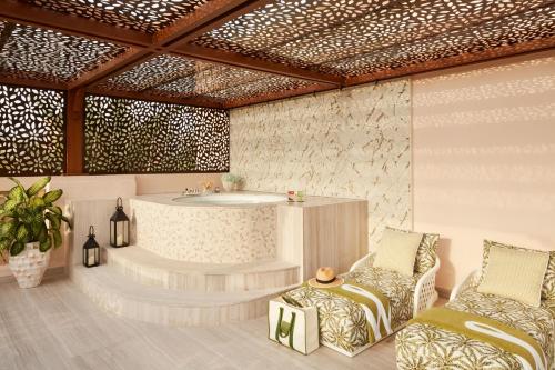 a rendering of a bathroom with a tub and two chairs at Jumeirah Dar Al Masyaf Dubai in Dubai