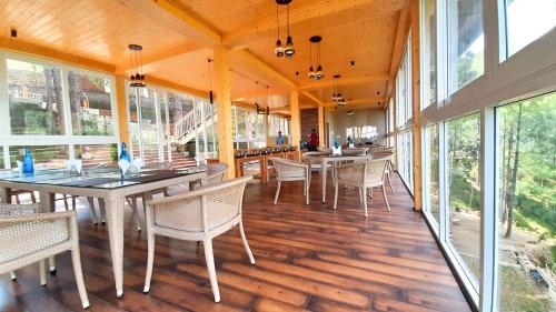 a dining room with tables and chairs and windows at The Woods Retreat in Lansdowne