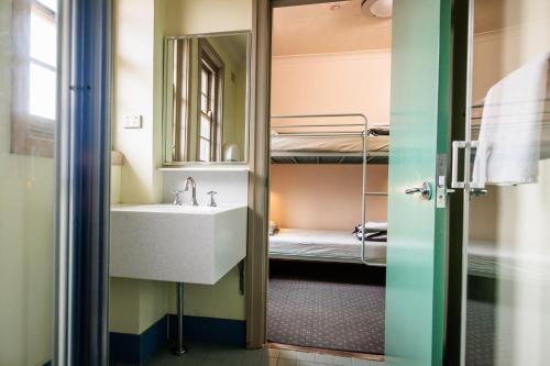 La salle de bains est pourvue d'un lavabo et de lits superposés. dans l'établissement YHA Blue Mountains Katoomba, à Katoomba
