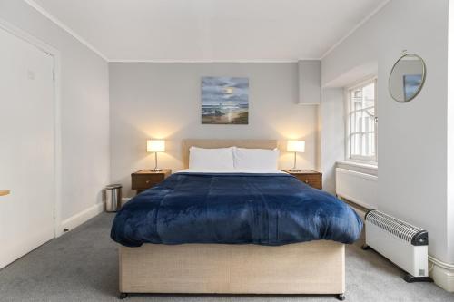 a bedroom with a large bed with blue sheets at Russell Square Vintage - 2 Cozy Bed Home in London