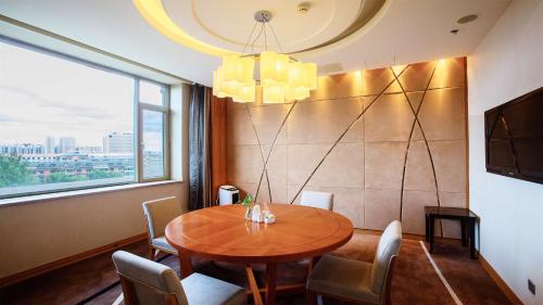 a dining room with a table and a large window at Holiday Inn Mudanjiang by IHG in Mudanjiang