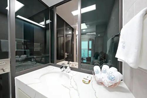 a bathroom with a sink and a large mirror at Elmomento Gwangan in Busan