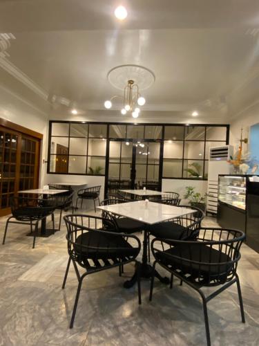 a restaurant with tables and chairs in a room at Honey Suite Room Inside Bee Cafe Cebu at Ayala Area in Cebu City