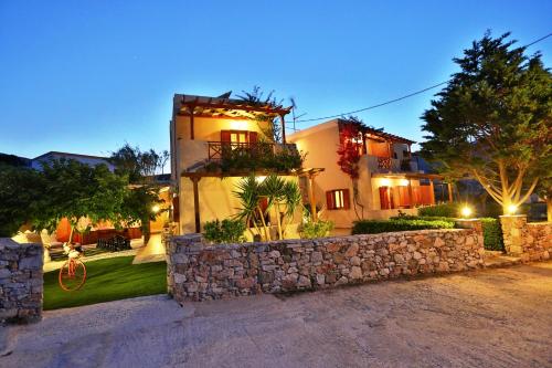 a house with a stone wall in front of it at Ventoura Studios & Apartments in Galissas
