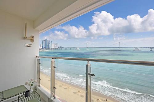 een balkon met uitzicht op het strand en een brug bij Elmomento Gwangan in Busan