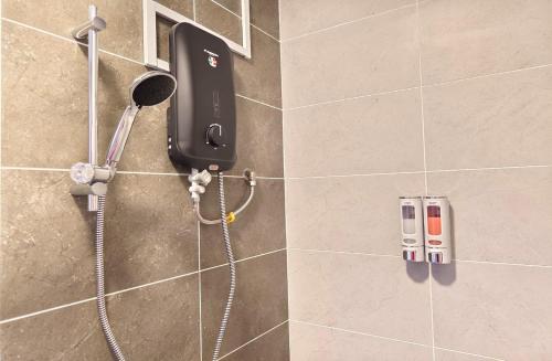 - un téléphone installé sur le mur d'une douche dans la salle de bains dans l'établissement Twin Tower Johor Bahru by Glex, à Johor Bahru