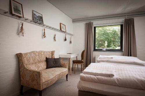 a bedroom with a bed and a chair and a desk at Jägerhuset in Maribo