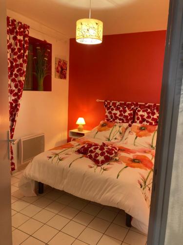um quarto com uma cama com uma parede vermelha em La Cigale Ardéchoise em Labégude