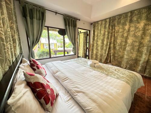 a bedroom with a large bed and a window at Soft Resort Kad Farang Hangdong in Ban Yang Plao