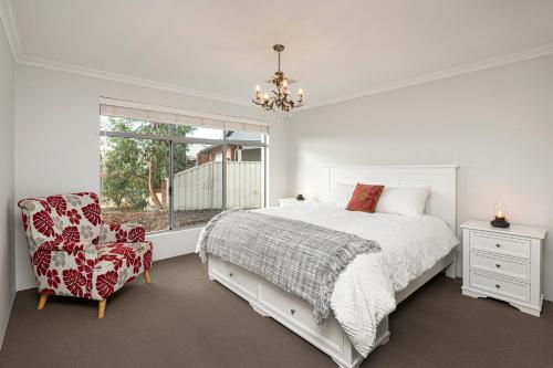Un dormitorio con una cama y una silla y una ventana. en Jakes Place, en Dunsborough