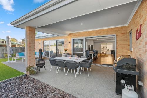a patio with a table and chairs and a grill at Jakes Place in Dunsborough