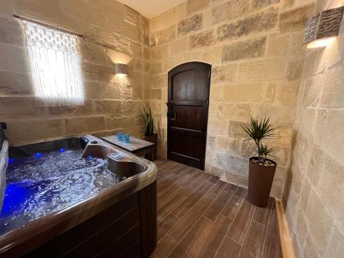 bagno con vasca e lavandino di House with pool & jacuzzi for 5 persons a Nadur